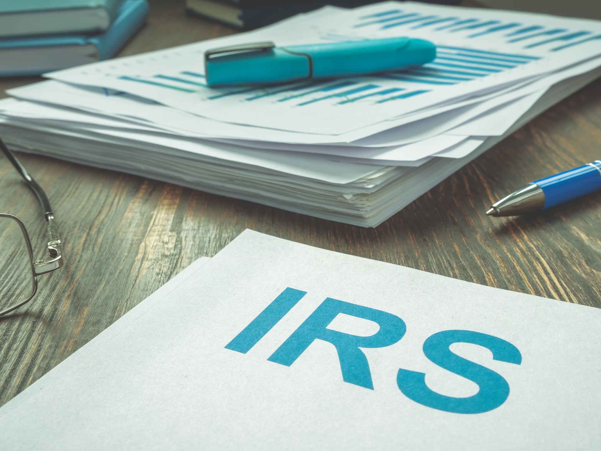 Abbreviation IRS and stack of financial papers.